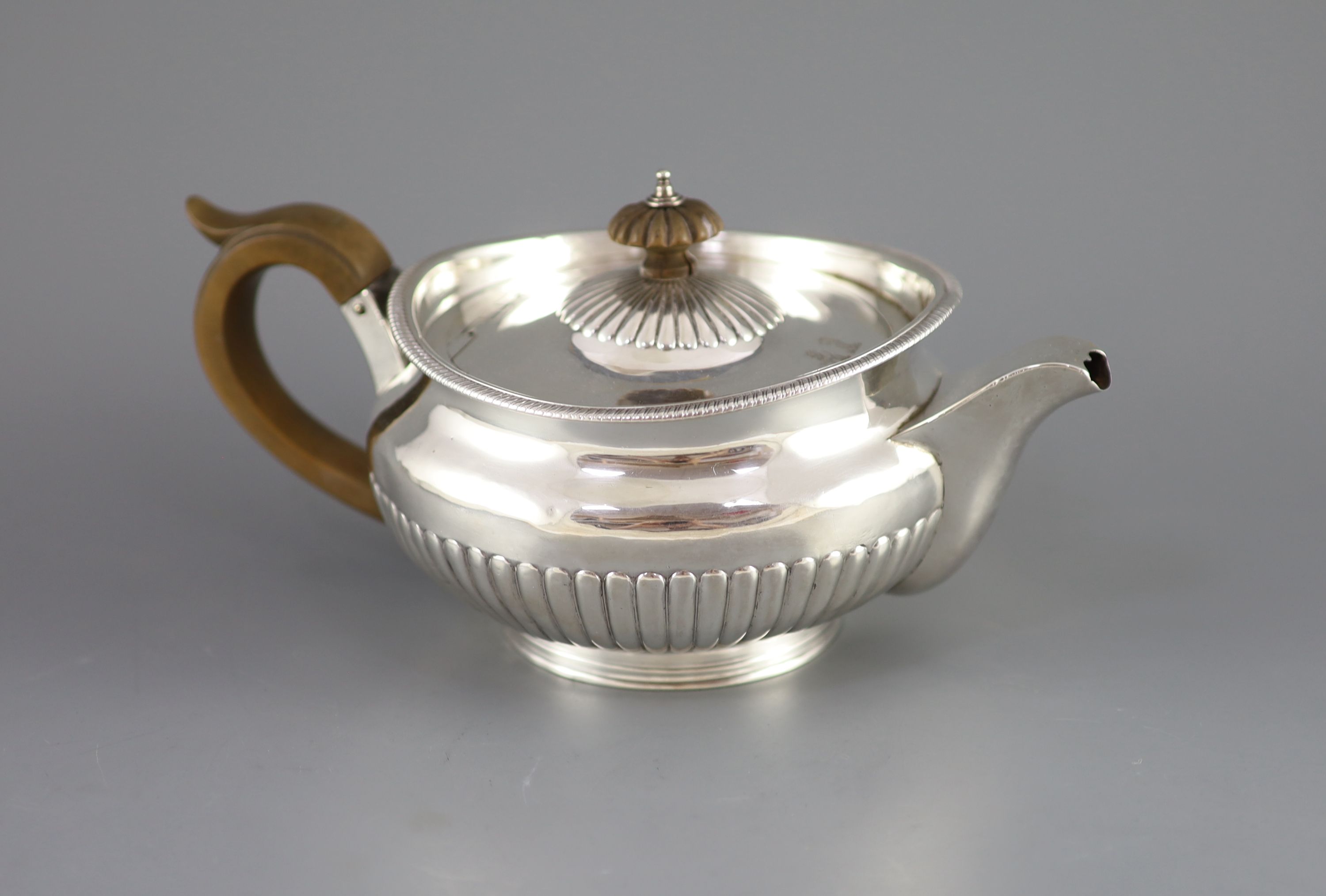 A George III demi-fluted silver squat circular teapot, by Robert & Samuel Hennell